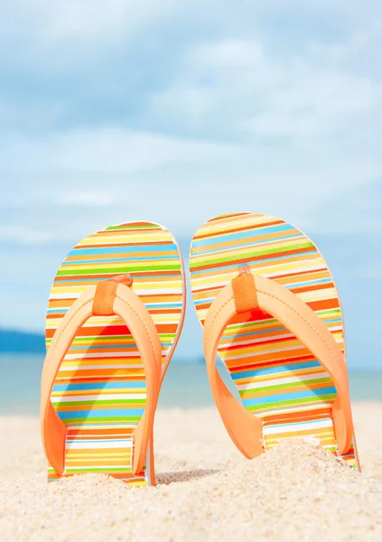 Helgdagar bakgrund. Strandsandaler på sandkusten — Stockfoto