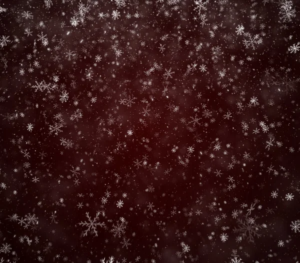 Copos de nieve cayendo sobre un fondo rojo oscuro —  Fotos de Stock