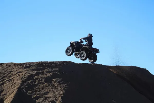 Силует чоловіка, що стрибає з квадроциклом на блакитне небо — стокове фото
