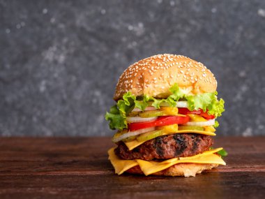 Tahta bir arka planda sulu et pirzolası, otlar ve sebzeler, köy tarzı hamburgerler..