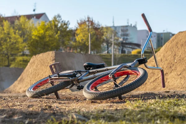 BMX bike on the track with jumps on the background with houses. Jumping track for bicycles in the city. — Zdjęcie stockowe