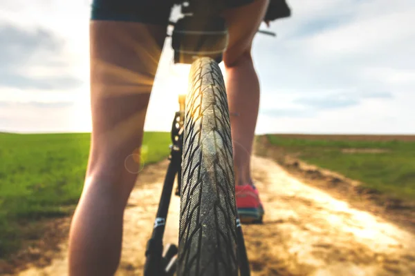 Close up view of a bicycle tire protector. Rear view of a bicycle wheel on a country road at sunny day. Cycling on a beautiful sunny day. Bike touring. — Stock Photo, Image