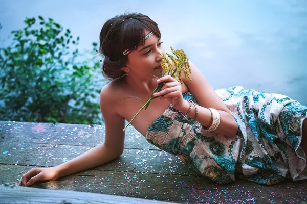 Girl sitting by a lake — Stock Photo, Image