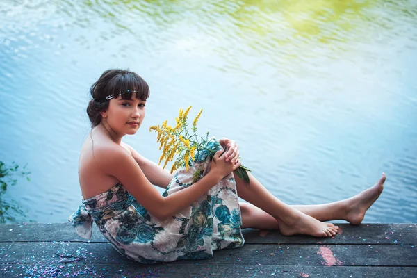 Menina sentada junto a um lago — Fotografia de Stock