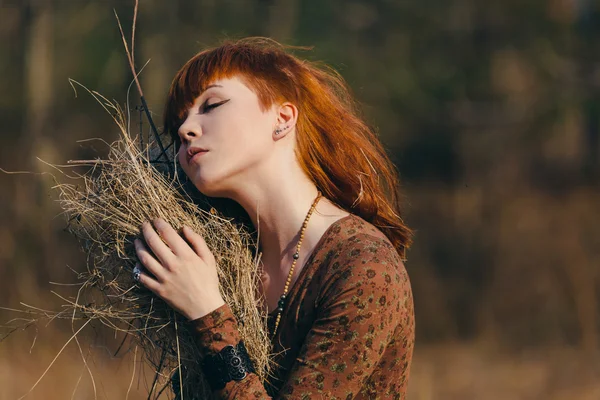 Young woman walking in golden dried grass field — Stock Photo, Image