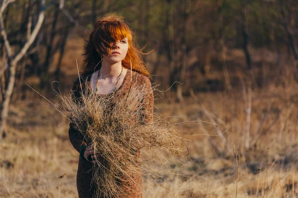 Jovem mulher andando no campo de grama seca dourada — Fotografia de Stock