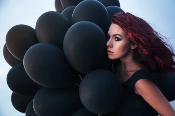 Güzel kız siyah balonlarla yürüyüş — Stok fotoğraf