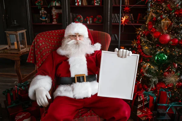 Santa Claus sosteniendo el marco blanco en sus manos —  Fotos de Stock