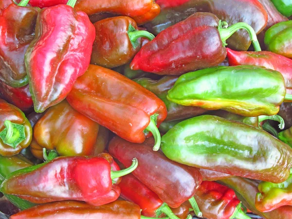 Rode en groene paprika's op een markt — Stockfoto