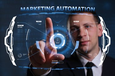 İş, Teknoloji, İnternet ve ağ konsepti. Genç işadamı geleceğin sanal ekranı üzerinde çalışıyor ve yazıyı görüyor: pazarlama otomasyonu