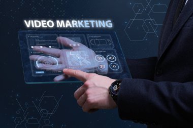 İş, Teknoloji, İnternet ve ağ konsepti. Finansal Grafik. Borsa çizelgesi. Genç işadamı geleceğin sanal ekranı üzerinde çalışıyor ve yazıyı görüyor: video pazarlama