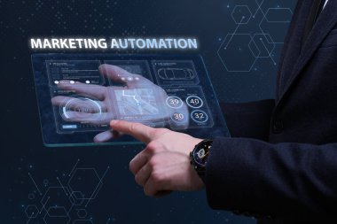 İş, Teknoloji, İnternet ve ağ konsepti. Finansal Grafik. Borsa çizelgesi. Genç işadamı geleceğin sanal ekranı üzerinde çalışıyor ve yazıyı görüyor: pazarlama otomasyonu