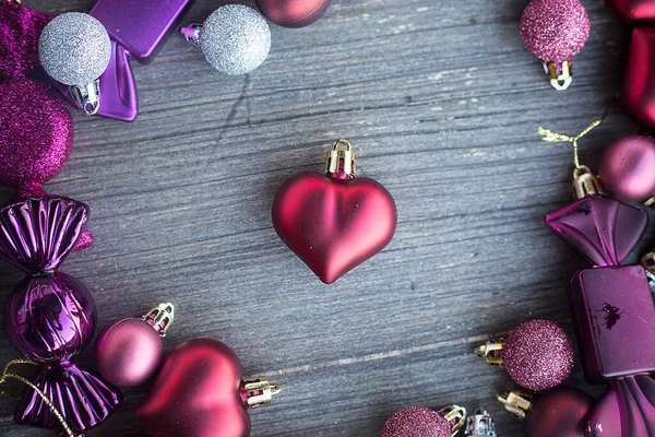 Christmas heart close up with colourful balls and candies around Wooden grey surface. Flat layer composition. Holiday card. Invitation background. Tender and love concept. Royalty Free Stock Images