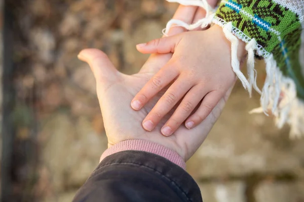 Babies hand on open moms palm. Partnership and respect concept. Different generations. growing together. closeup of childs hand on a grownups hand. High quality photo