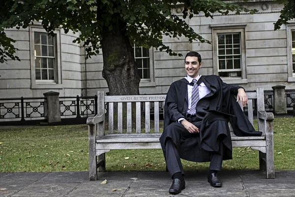Młody człowiek z kasztana i suknia i dyplom uśmiechający się — Zdjęcie stockowe