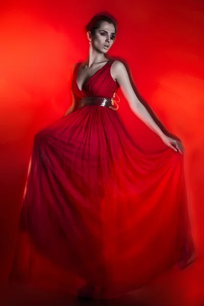 Красива гаряча брюнетка закохана в червону сукню на червоному — стокове фото