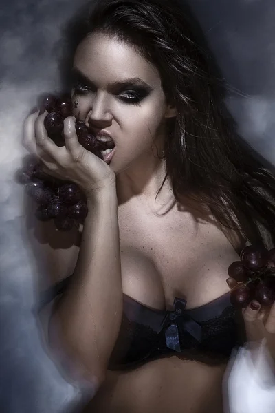 Joven sexy playboy playmate mujer modelo usando lencería sosteniendo uvas posando —  Fotos de Stock