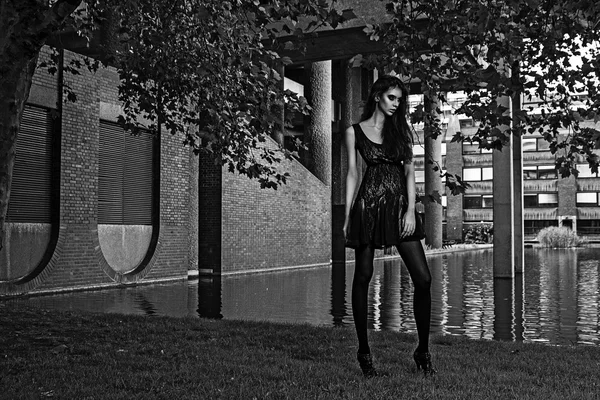 Jeune mannequin de mode en plein air shoot posant en robe noire courte — Photo