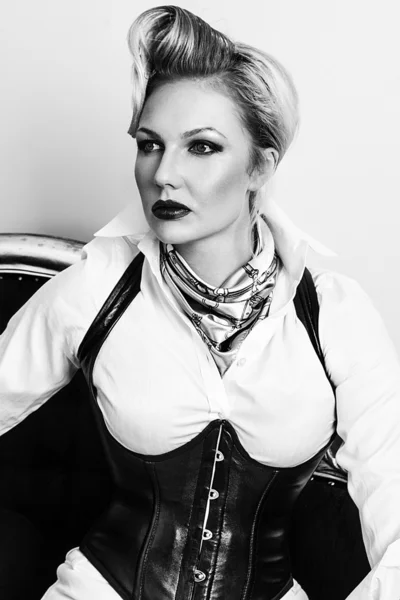 A young blond sexy lady mistress with bright red lips wearing a black leather corset — Stock Photo, Image