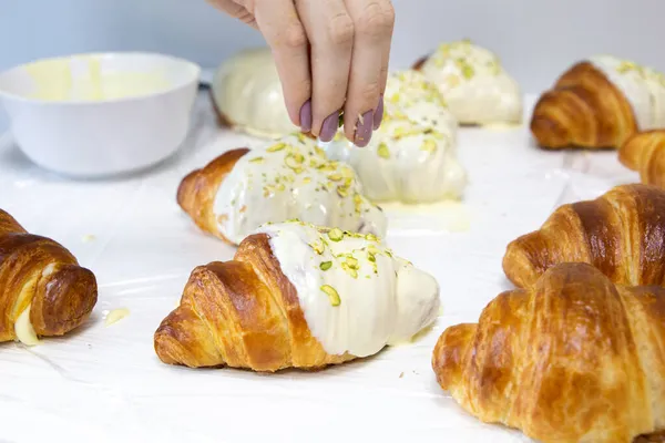 Bäcker Dekoriert Frisch Gebackenes Croissant Mit Pistazienkernen Süßes Handgemachtes Dessert — Stockfoto