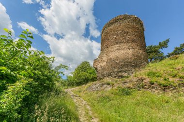 Rabstejn nad Strelou, Çek Cumhuriyeti - 12 Haziran 2022: Dik bir tepede duran eski Sychrov şatosunun bir parçası olan taş kulenin manzarası. Yeşil çimenler, patika yukarı çıkıyor. Güneşli yaz günü.