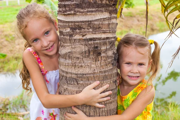 两个快乐姐妹附近的一棵树 — 图库照片