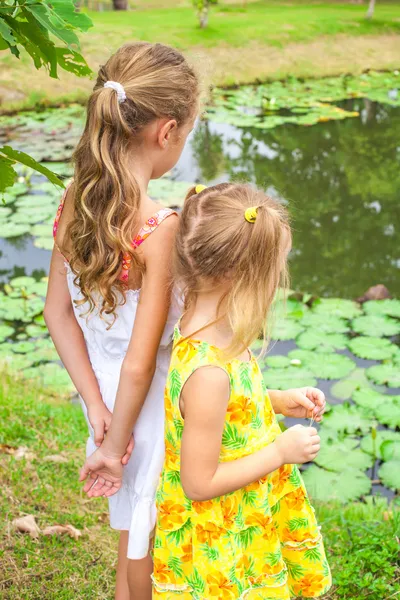 Two girls standing near pond — Stok fotoğraf