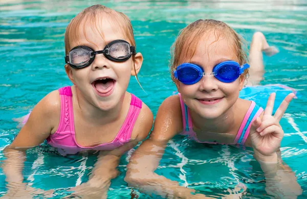 Two little girls playing in the pool — Stock Photo, Image