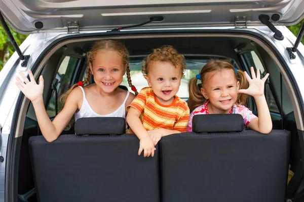 Tre glada barn i bilen — Stockfoto