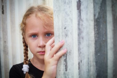 bir duvarın arka planda üzgün küçük kız