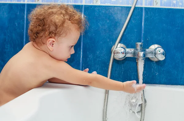 Bonito menino de um ano tomando um banho relaxante com espuma . — Fotografia de Stock