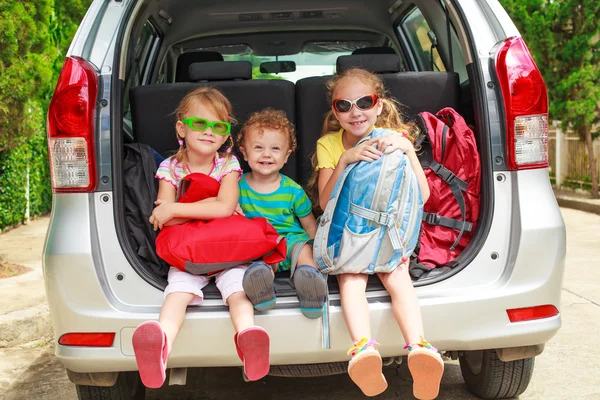 Trois enfants heureux dans la voiture — Photo