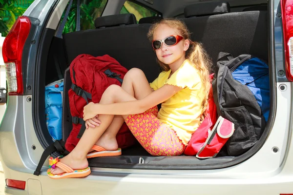 バックパックが付いている車に座っている小さな女の子 — ストック写真