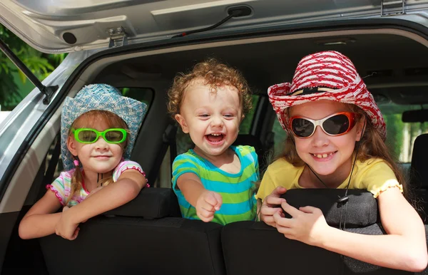 Tre bambini felici in macchina — Foto Stock