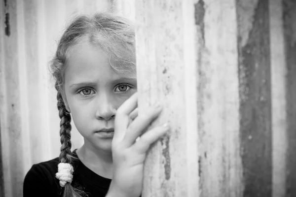 Trauriges kleines Mädchen an der Wand — Stockfoto