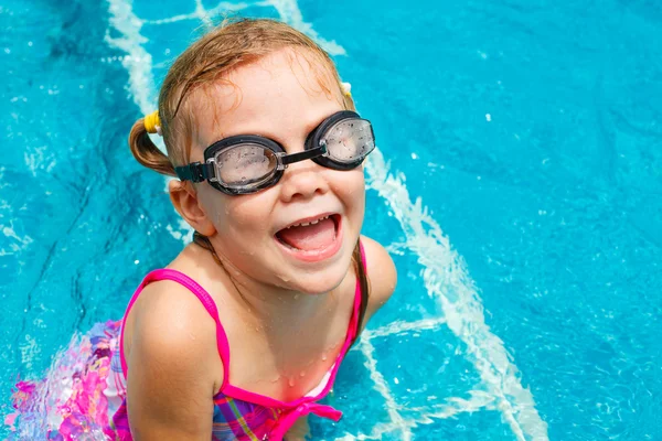 Glückliches kleines Mädchen planscht im Pool herum — Stockfoto