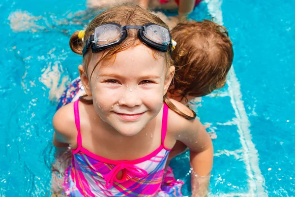 Menina feliz salpicando ao redor na piscina — Fotografia de Stock