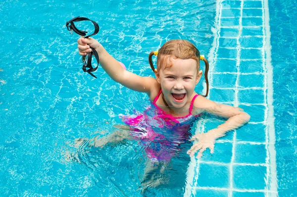 Щаслива маленька дівчинка кружляє в басейні — стокове фото