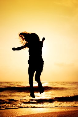 mutlu kız sahilde günbatımı zaman içinde atlama