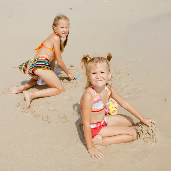 Two kids playing on beach — Stock Photo, Image