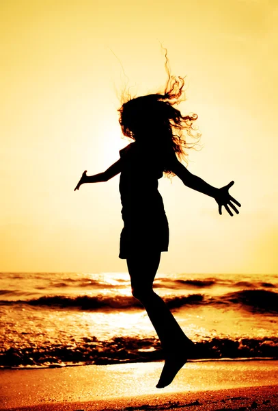 Silhueta de criança pulando no por do sol — Fotografia de Stock
