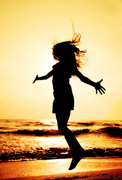 silhouette of child jumping in sunset