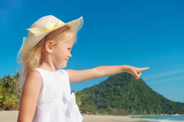 Glückliches kleines Mädchen, das am Strand steht und sich am Strand zeigt — Stockfoto