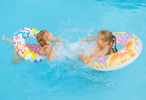Две маленькие девочки играют в бассейне — стоковое фото