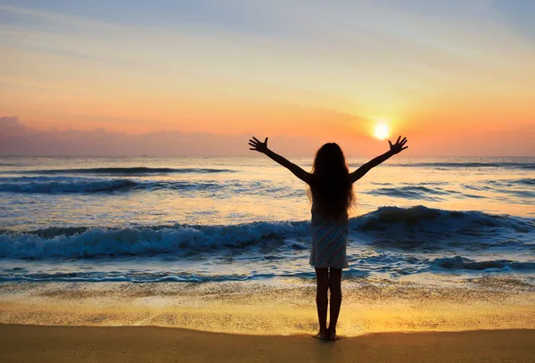 Silhouet van het meisje permanent op het strand tijdens prachtige su — Stockfoto