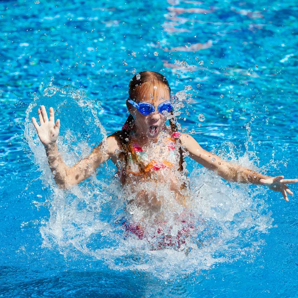 Heureuse petite fille éclaboussant dans la piscine — Photo