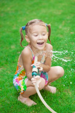 mutlu kız bir hortum su dökülen