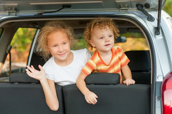 Двое счастливых детей в машине — стоковое фото