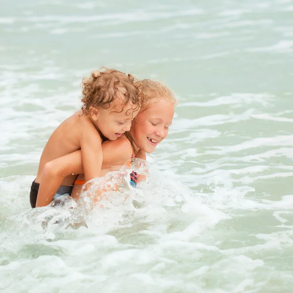 Enfants heureux jouant sur la plage — Photo
