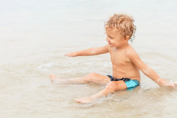 Malý chlapec hraje na pláži. — Stock fotografie